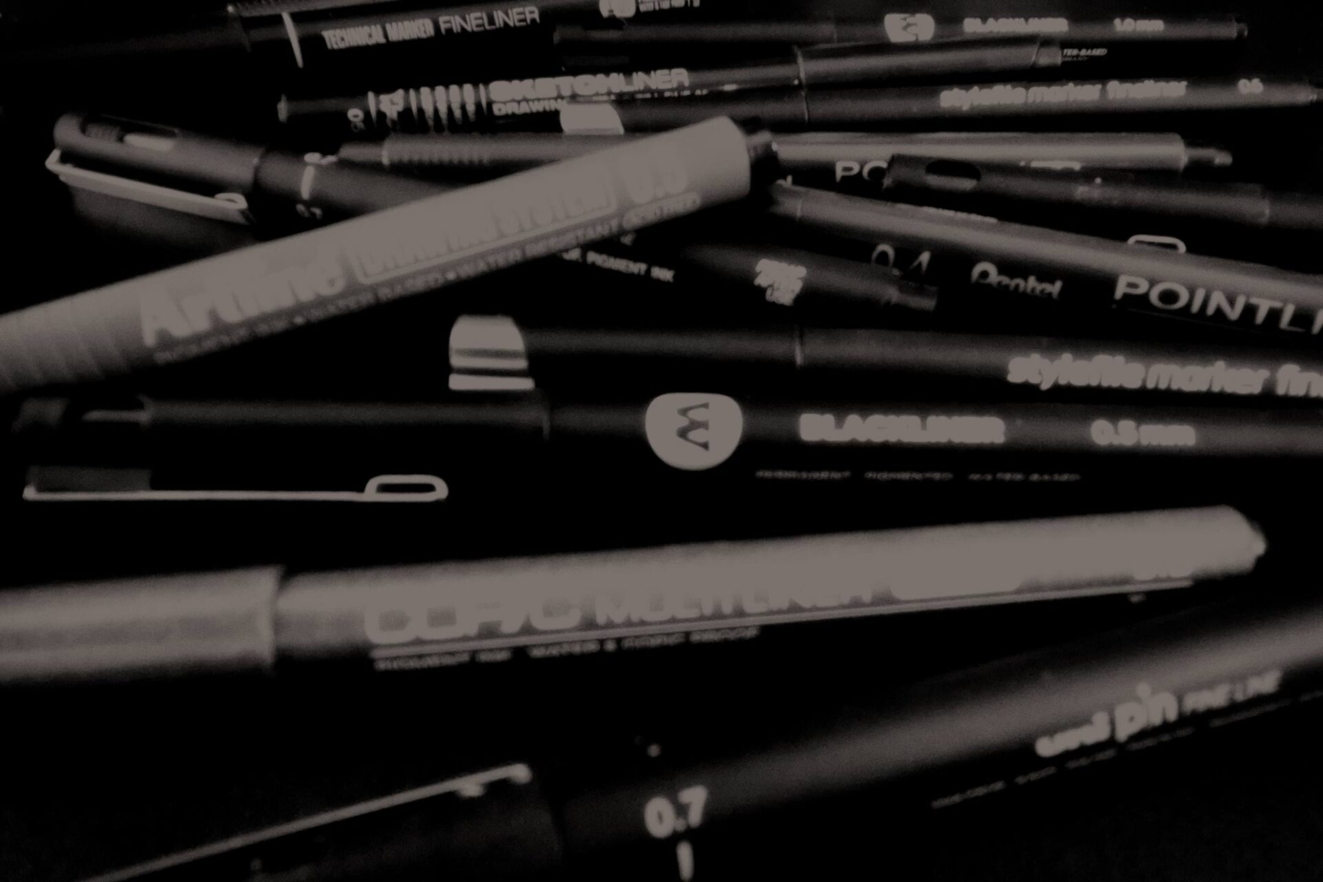 Close up of collection of various black markers.