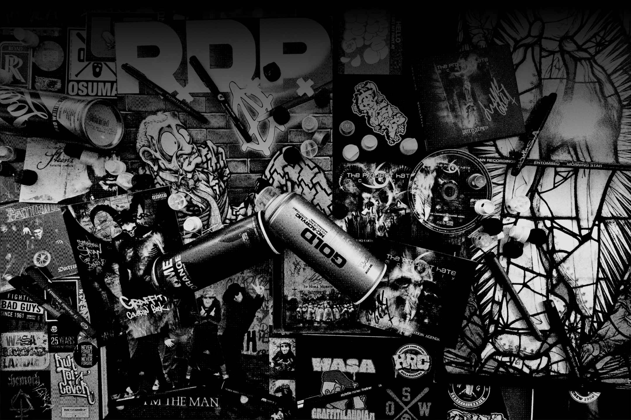 Grainy black and white picture of albums, cd's, pens and spraypaint.