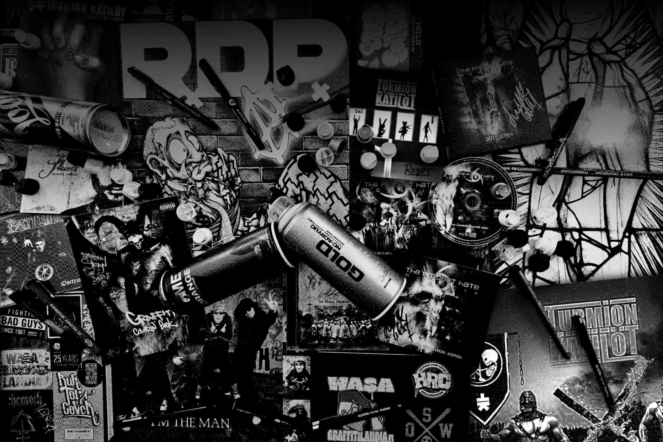 Grainy black and white picture of albums, cd's, pens and spraypaint.
